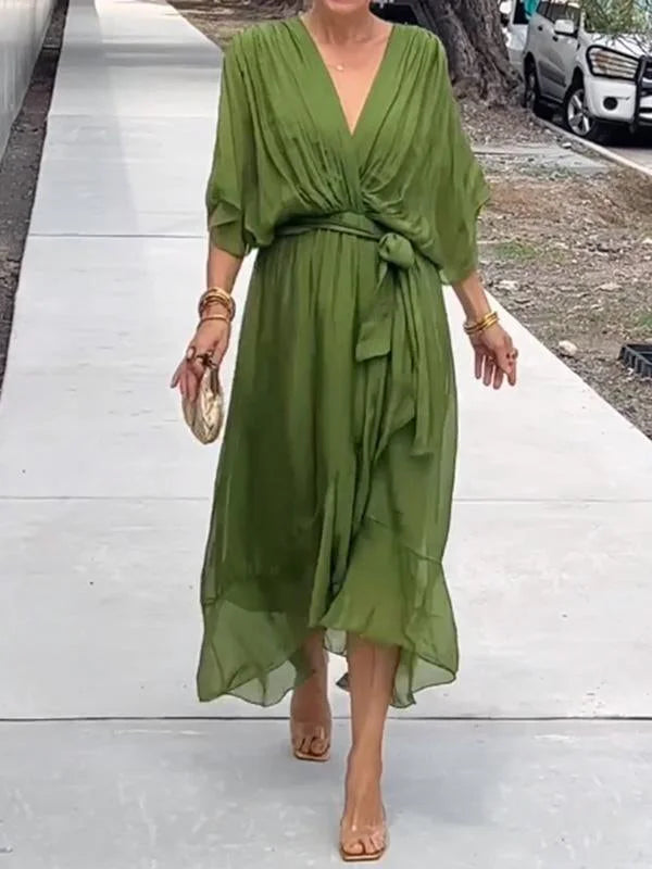 Robe midi vert olive portefeuille, vue de dos en marche, coupe ample et ceinture, look chic décontracté