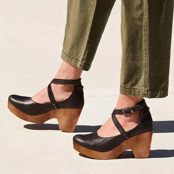 Sandales élégantes noir pour femme avec brides croisées, talon en bois et bout arrondi, portées avec pantalon kaki