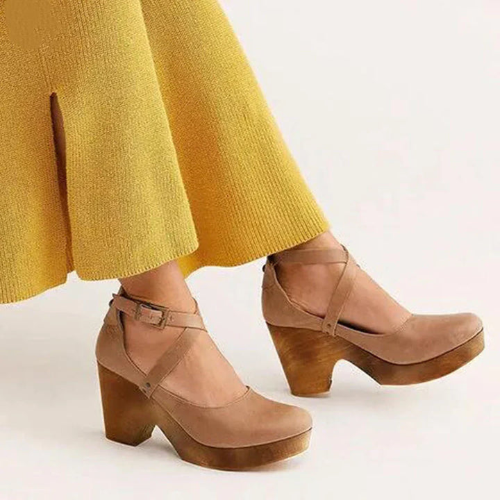 Sandales khaki élégantes avec brides croisées et talon en bois, portées avec une jupe jaune