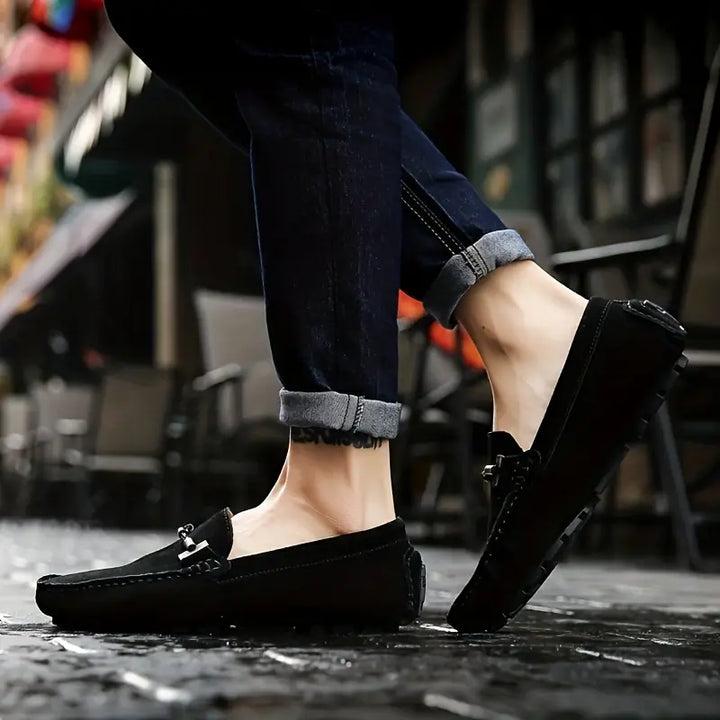 Mocassins noir pour homme portés en extérieur, style élégant avec bout arrondi et détail argenté