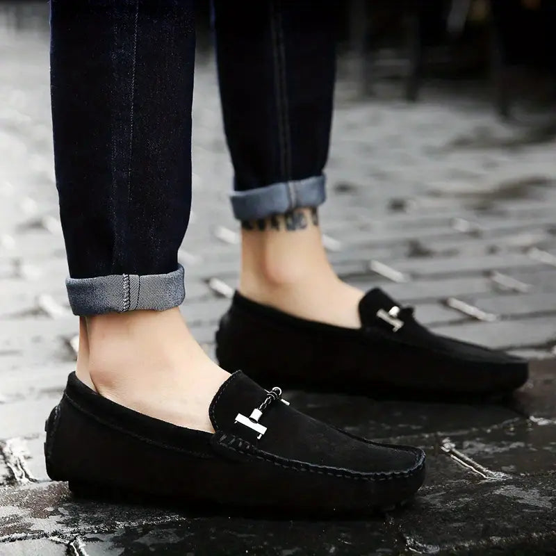 Homme portant des mocassins noir élégants sur sol pavé, design moderne et confortable