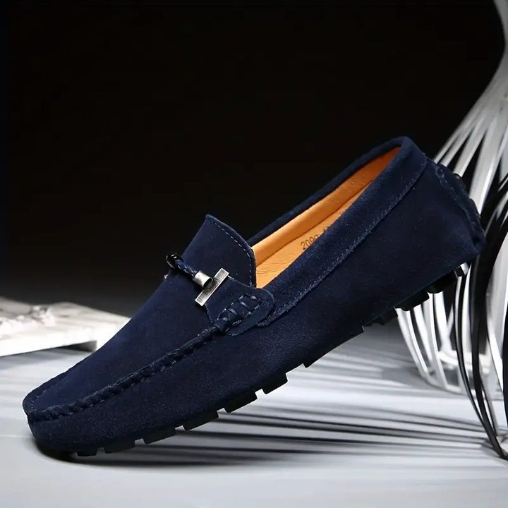 Mocassins bleu pour homme en vue latérale, avec détail métallique et coupe élégante