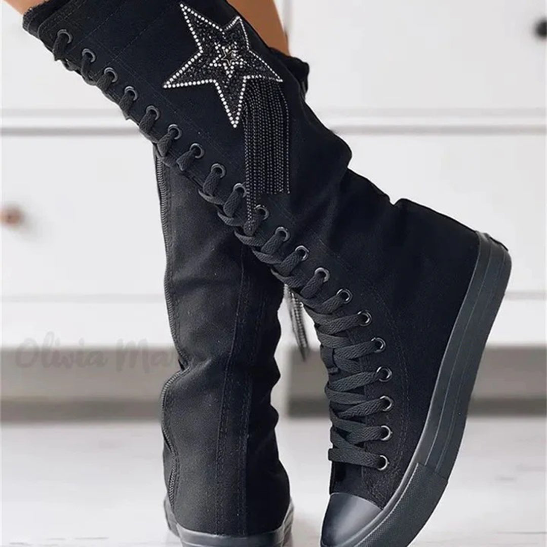 Vue latérale des bottes sneakers noires pour femme avec semelle épaisse, lacets et étoile sur le côté.