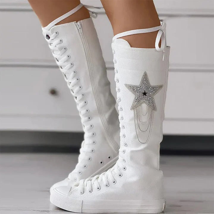 Vue de trois-quarts des bottes sneakers blanches mettant en valeur la tige montante et le design à étoile.