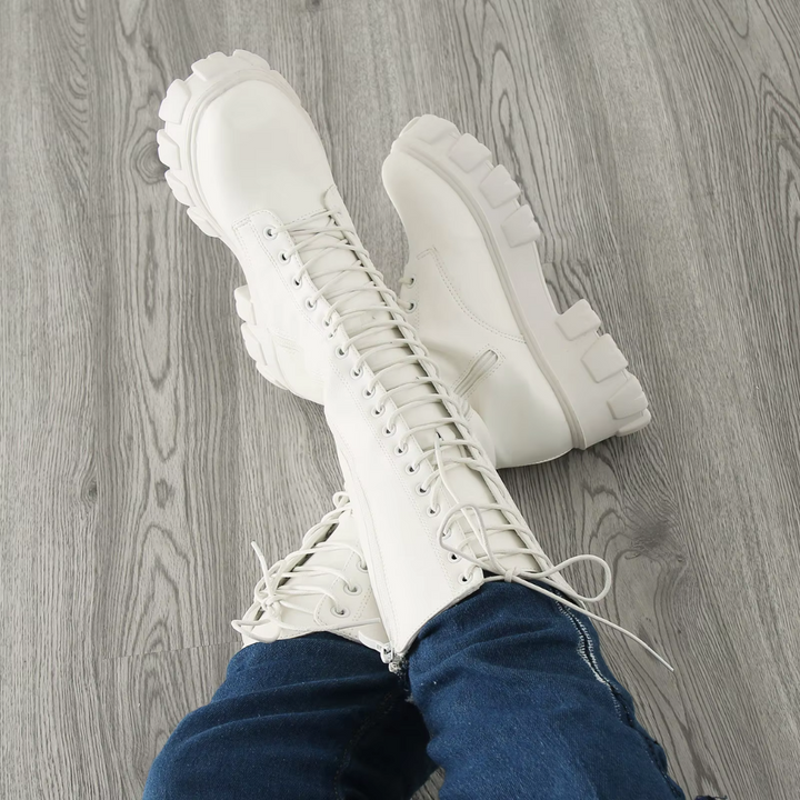 Bottes blanches à lacets pour femme, portées assise, vue rapprochée sur l’avant, focus sur la pointe et la semelle plateforme