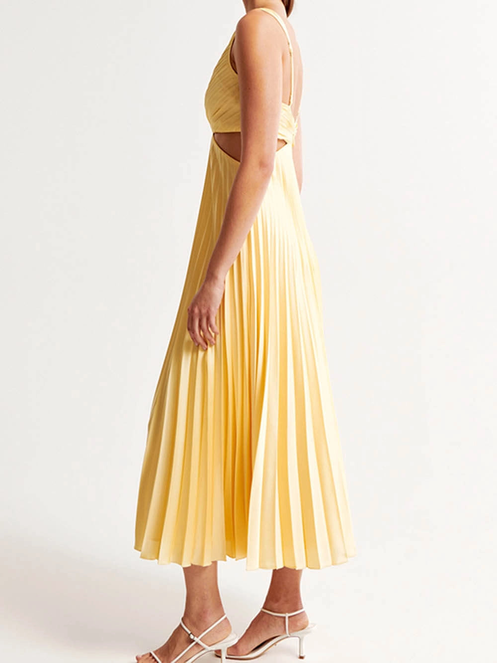 Vue latérale d’une robe jaune élégante pour femme mettant en valeur les plis et la longueur midi