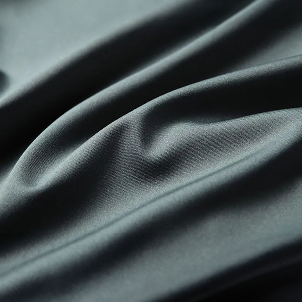 Gros plan sur le tissu en soie vert du polo homme, texture douce, lisse et élégante