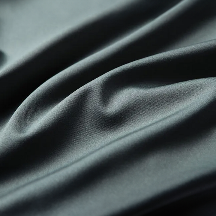 Gros plan sur le tissu en soie vert du polo homme, texture douce, lisse et élégante