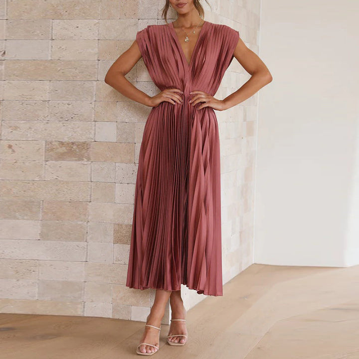 Robe longue rose rouge à col en V portée de face, mettant en valeur la taille cintrée et la jupe plissée élégante.