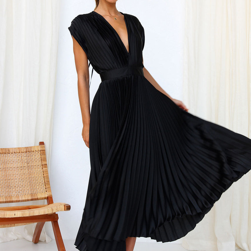 Robe longue noire à col en V présentée en mouvement, avec une large jupe plissée fluide et une coupe élégante.