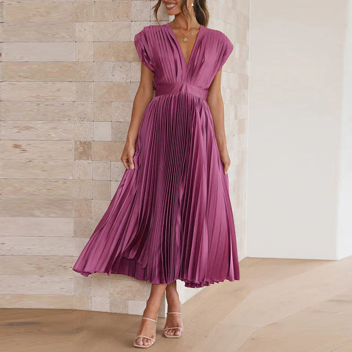 Robe longue couleur paire à col en V portée de face, avec une taille cintrée et une jupe plissée légèrement évasée.