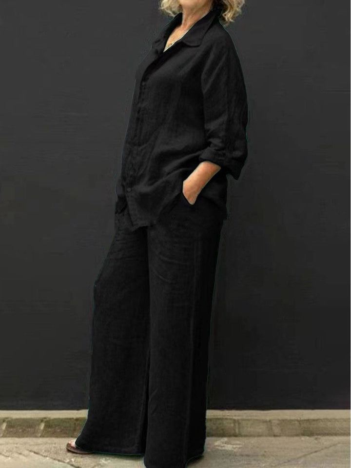 Ensemble femme noir en coton et lin composé d’une chemise ample et d’un pantalon large assorti, porté de profil dans un style moderne et décontracté.