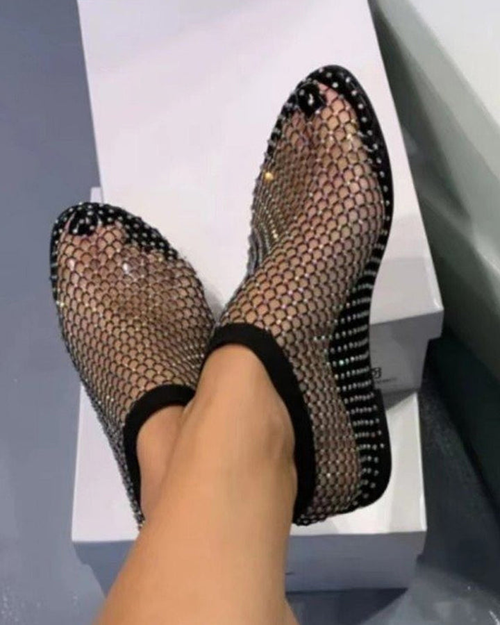 Vue de dessus de sandales plates noir avec strass scintillants et maille légère pour l’été