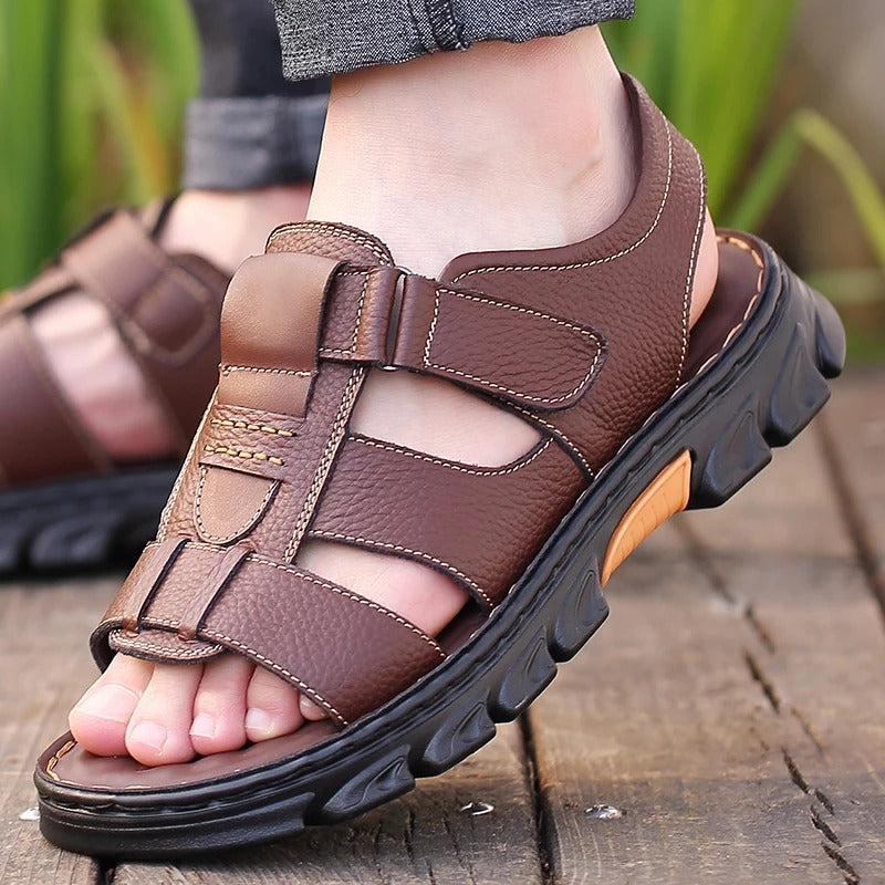Sandales orthopédiques marron pour homme avec brides fermées, portées avec un pantalon foncé en extérieur