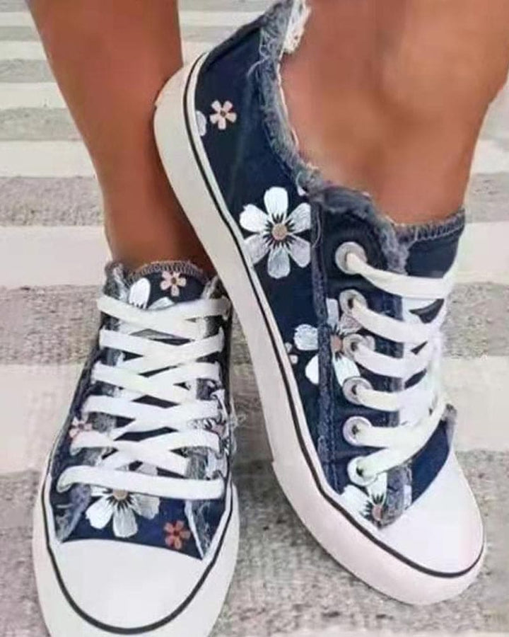 Baskets en denim fleuries bleu foncé pour femme avec imprimé floral blanc, lacets contrastés et style casual tendance