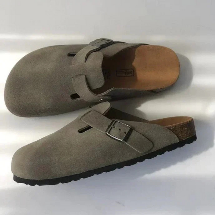 Paire de sabots gris foncé avec boucle réglable, photographiée de dessus pour montrer la forme ergonomique et la semelle.