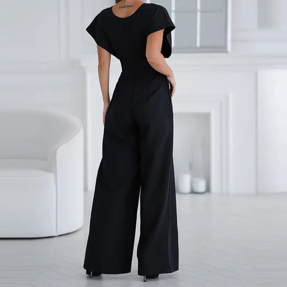 Vue complète d’une combinaison noir à jambes larges avec manches courtes fluides et silhouette élégante