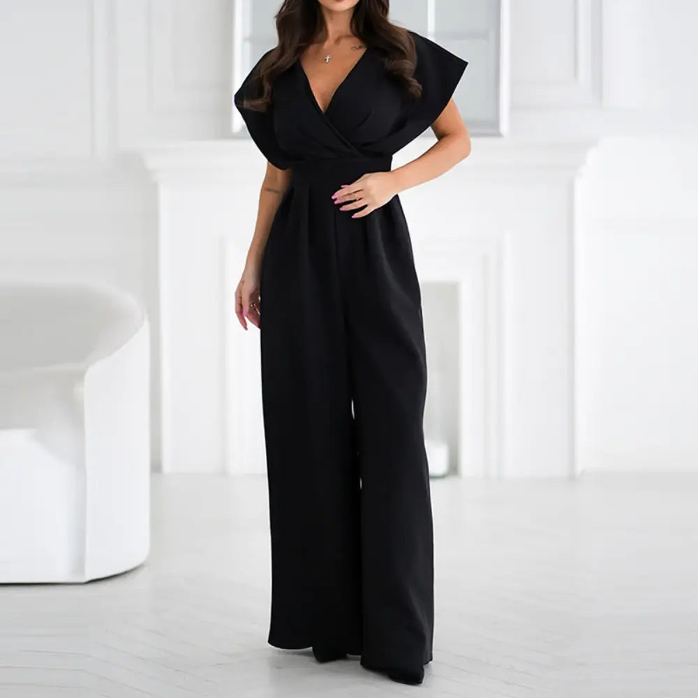 Femme portant une combinaison noir élégante avec décolleté en V et coupe moderne à jambes larges