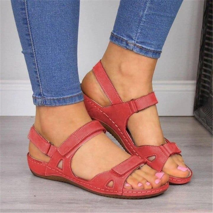 Sandales orthopédiques rouges pour femme portées de face, avec brides confortables et semelle ergonomique.