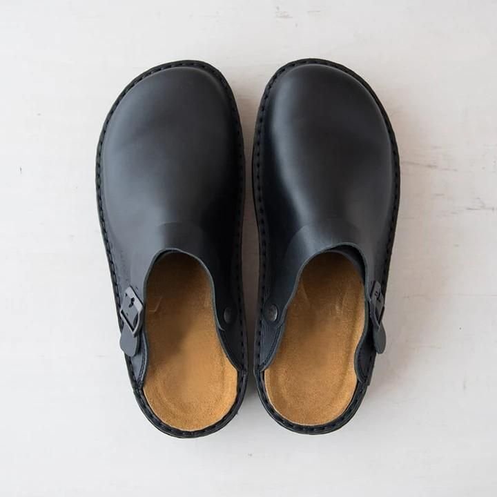 Vue de dessus des pantoufles orthopédiques en cuir noires avec semelle confortable sur fond blanc.