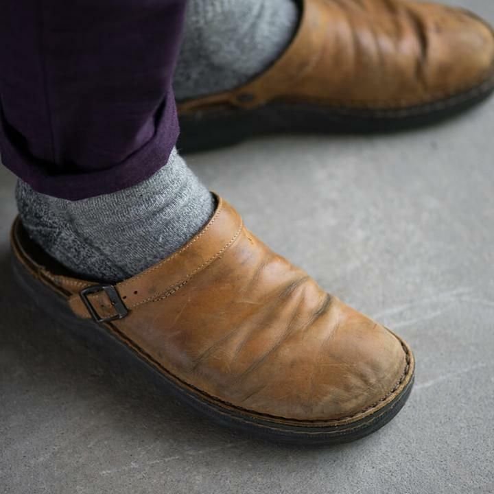 Pantoufle orthopédique en cuir beige portée au pied avec pantalon, montrant son confort et sa coupe ergonomique.