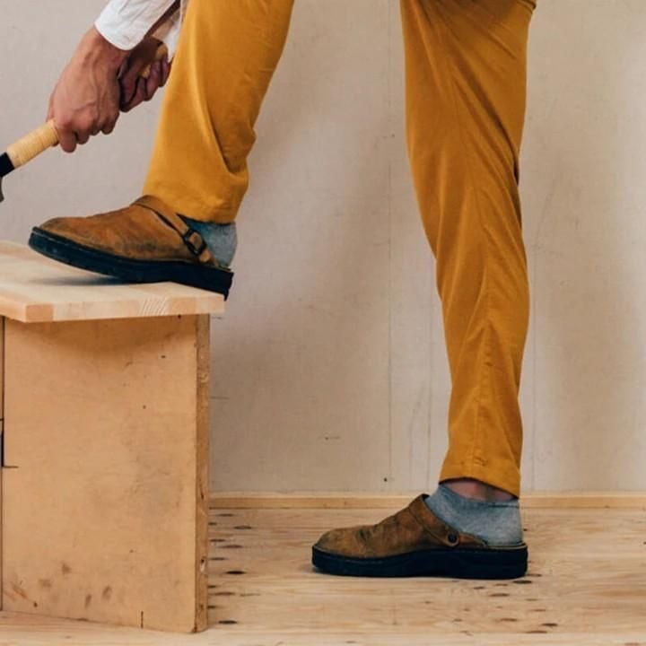 Pantoufle orthopédique en cuir beige portée avec un pantalon ocre, illustrant son confort au quotidien.