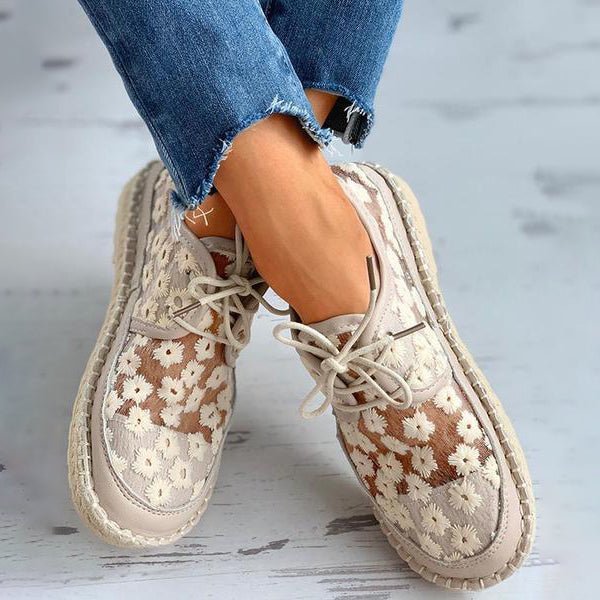 Chaussures orthopédiques beiges à motif floral portées de trois quarts, mettant en valeur la coupe confortable et les lacets.