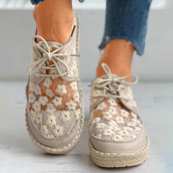 Vue latérale des chaussures orthopédiques beiges à motif floral avec plateforme et lacets assortis.