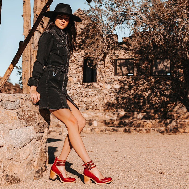 Bottines rouges avec boucles argentées portées en extérieur sur sol clair