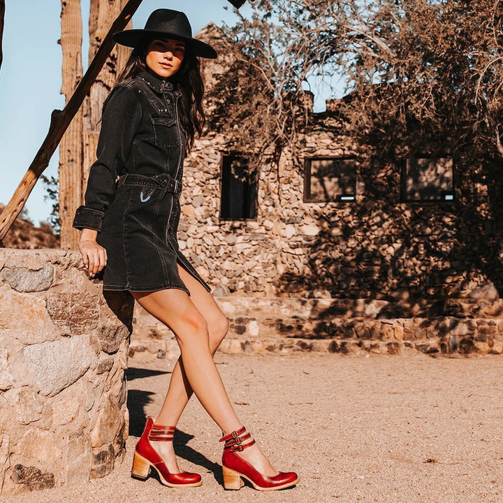 Bottines rouges avec boucles argentées portées en extérieur sur sol clair