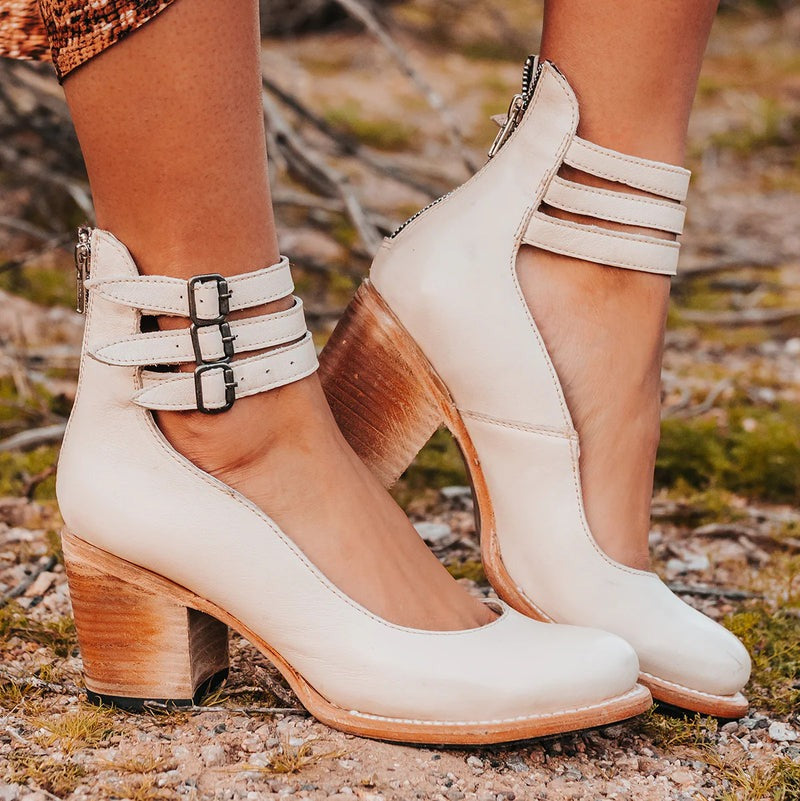 Bottines blanc cassé avec brides croisées autour de la cheville, portées en extérieur