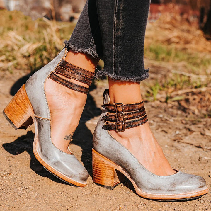 Bottines gris métallisé avec talon bois, posées sur fond clair