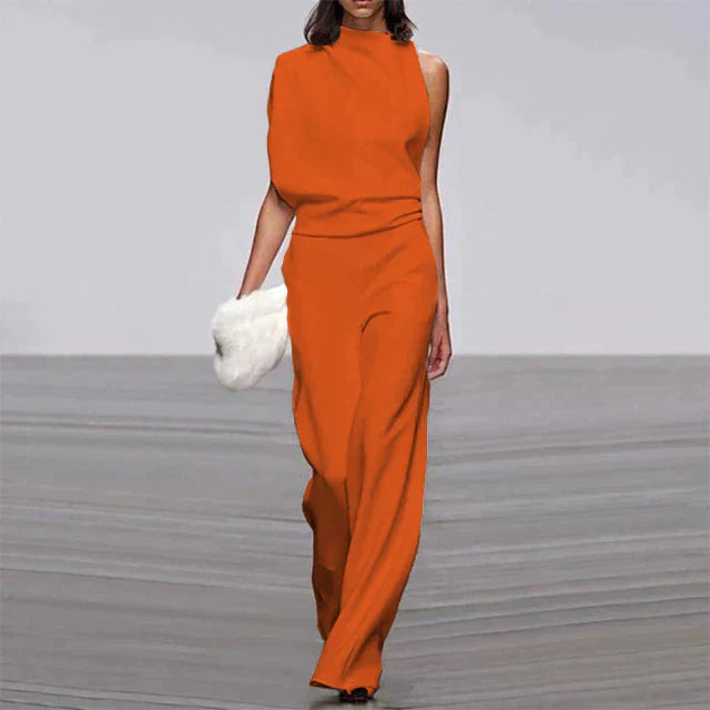 Combinaison orange élégante pour femme portée de face, avec un haut sans manches, une taille marquée et un pantalon fluide à jambes larges.