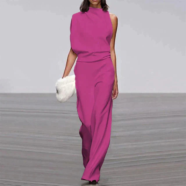 Combinaison rose rouge pour femme portée de face, avec une coupe sans manches, une taille marquée et un pantalon fluide à jambes larges.