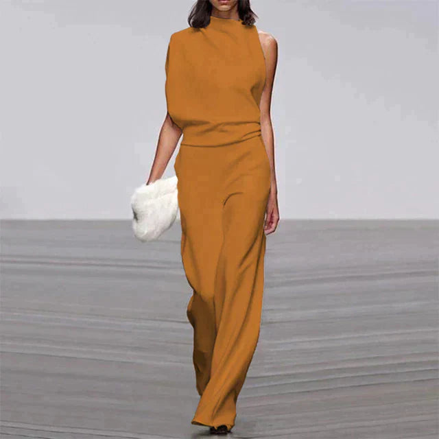 Combinaison jaune orangé pour femme portée de face, avec un haut sans manches, une taille ajustée et un pantalon ample et fluide.