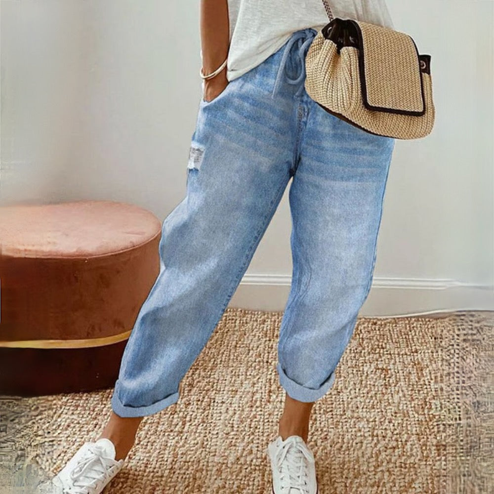 Jean femme bleu clair porté de face, avec une coupe ample et décontractée, des jambes fuselées et une longueur raccourcie aux chevilles.