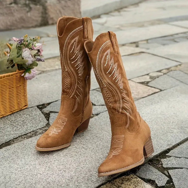Bottes cowboy marron brodées portées en marchant avec talon western robuste.