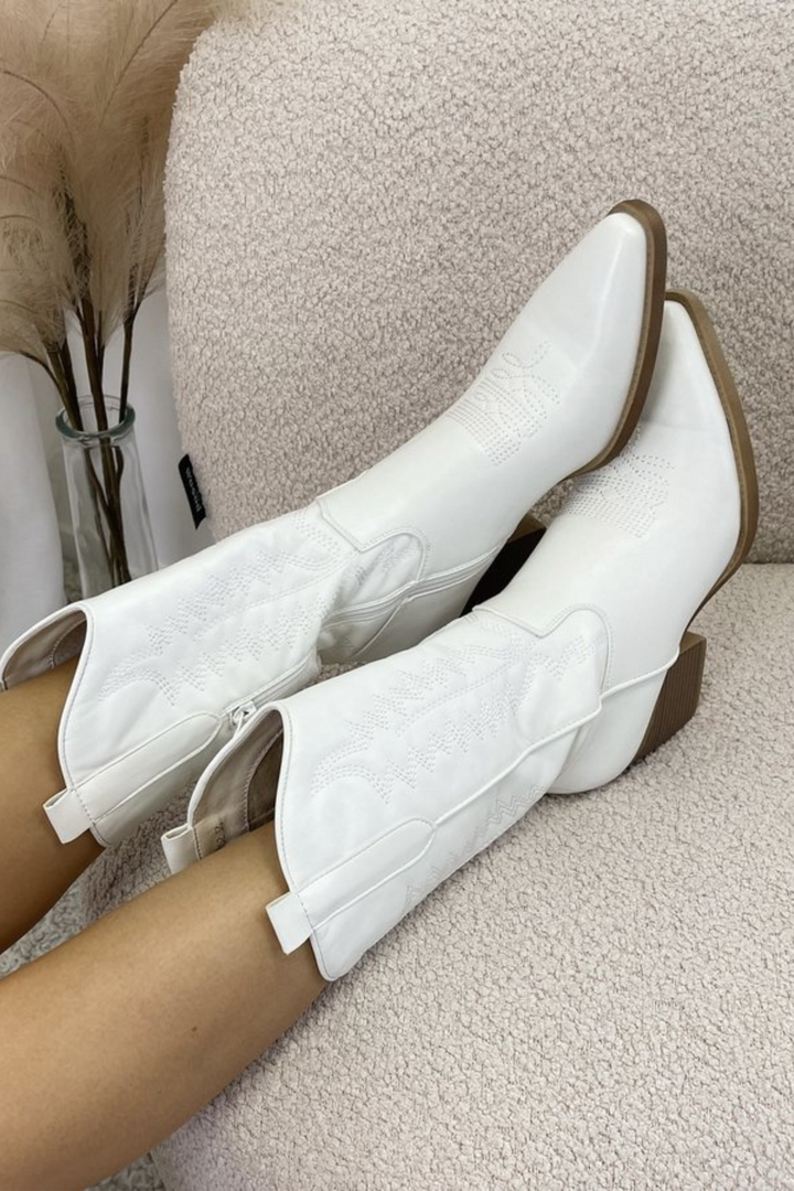 Bottes hautes blanches Rienara allongées sur canapé, bottes femme élégantes à talons pour look chic