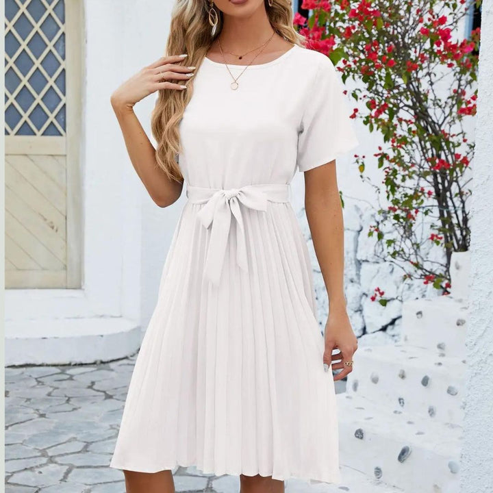 Vue latérale d’une robe blanche midi avec coupe fluide et détails plissés