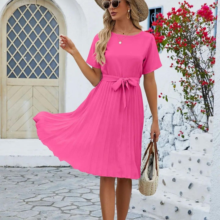 Robe rose élégante pour femme en mouvement mettant en valeur la coupe plissée