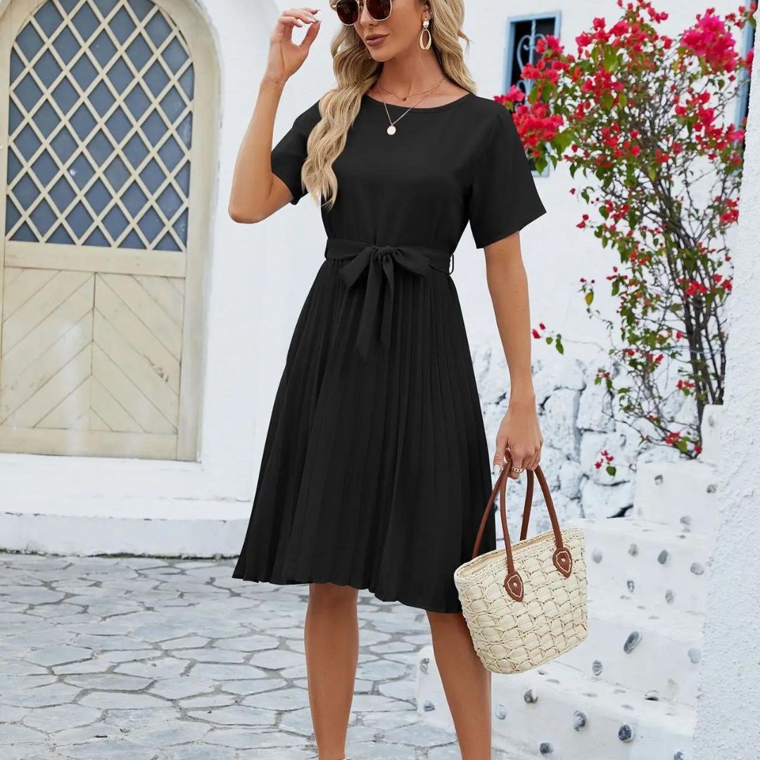 Robe noire plissée en mouvement mettant en valeur la fluidité de la jupe