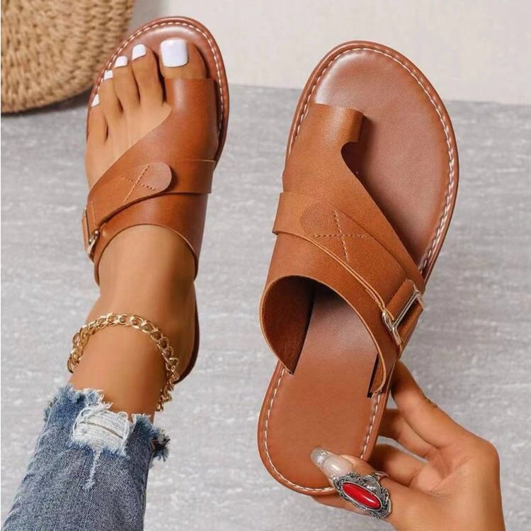 Sandales orthopédiques marron pour femme avec bride croisée, bout ouvert et semelle confortable, portées avec un jean