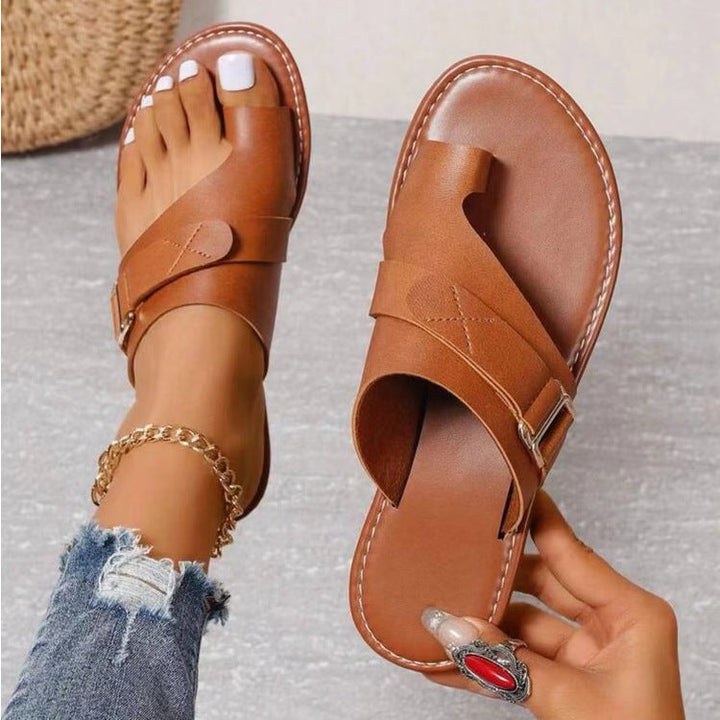 Sandales orthopédiques marron pour femme avec bride croisée, bout ouvert et semelle confortable, portées avec un jean