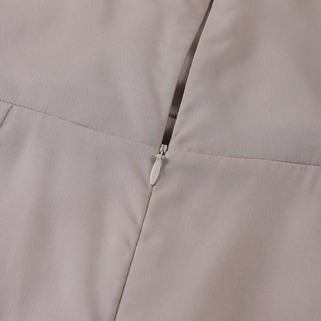 Détail de la fermeture éclair discrète au dos de la robe de soirée maxi beige pour femme