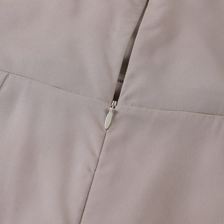Détail de la fermeture éclair discrète au dos de la robe de soirée maxi beige pour femme