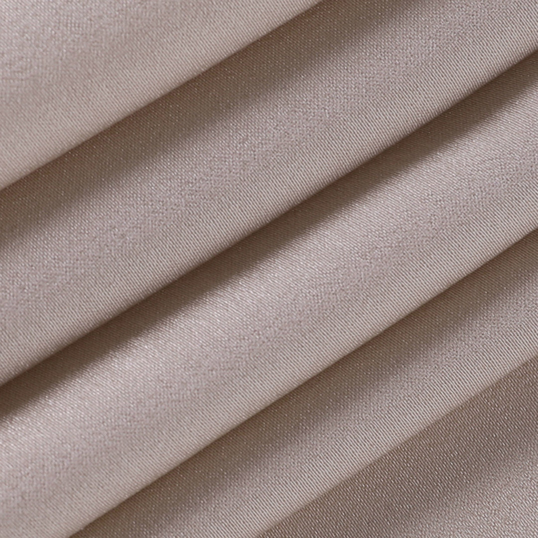 Gros plan du tissu beige plissé de la robe de soirée maxi pour femme montrant la texture légère