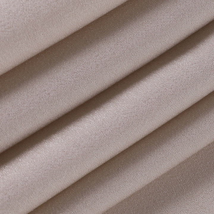 Gros plan du tissu beige plissé de la robe de soirée maxi pour femme montrant la texture légère