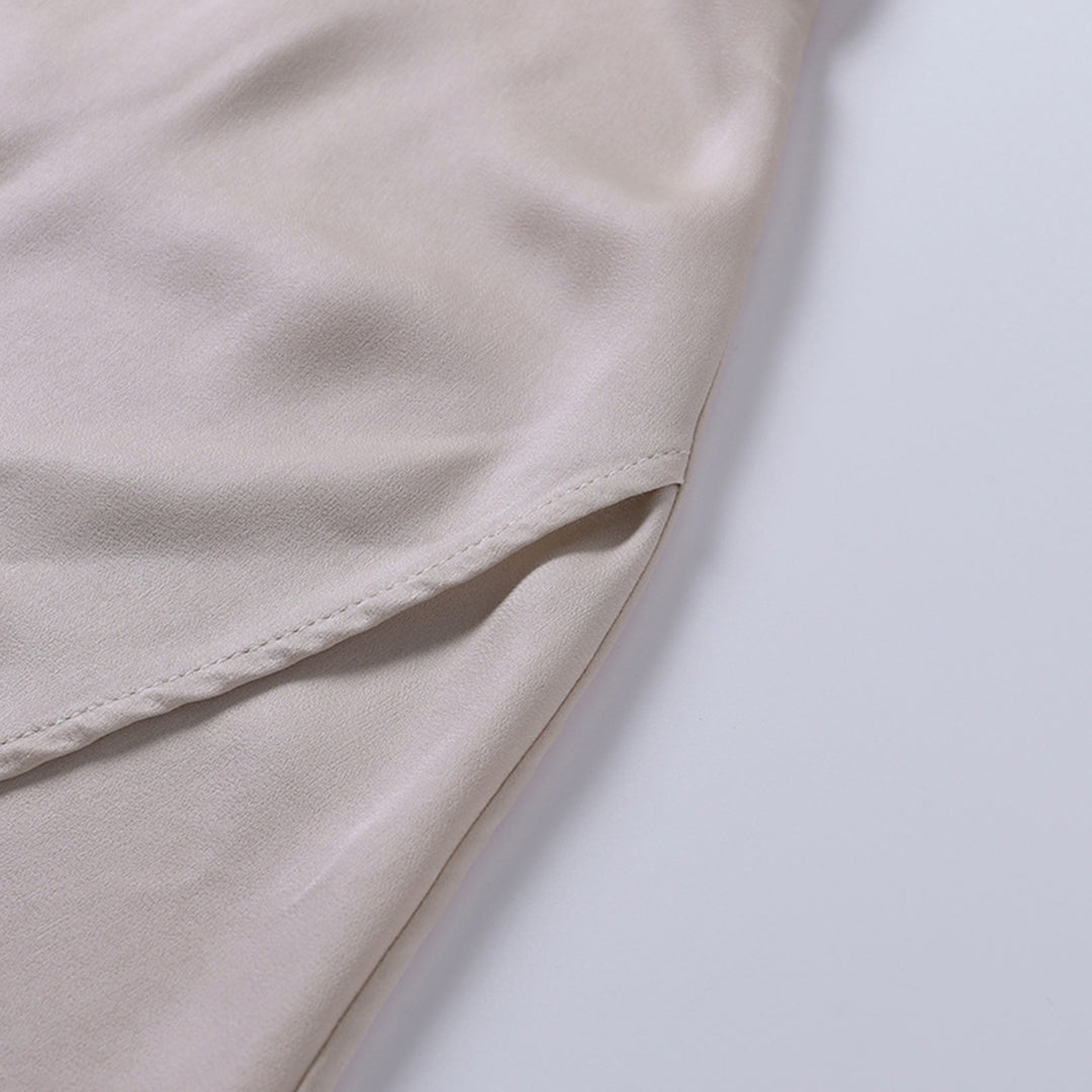 Gros plan du tissu beige satiné de la robe de soirée maxi pour femme