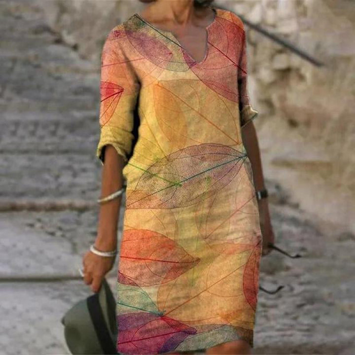 Robe élégante jaune et orange pour femme avec imprimé artistique, manches trois-quarts et silhouette féminine