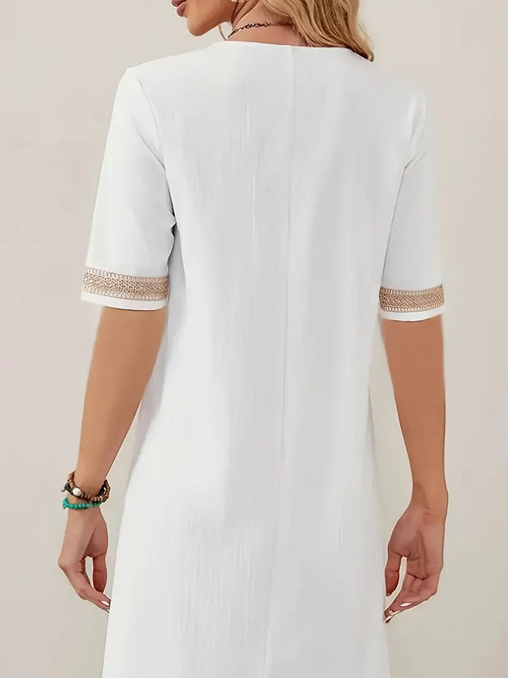 Vue de dos d’une robe blanc pour femme avec manches courtes, coupe décontractée et longueur au-dessus du genou